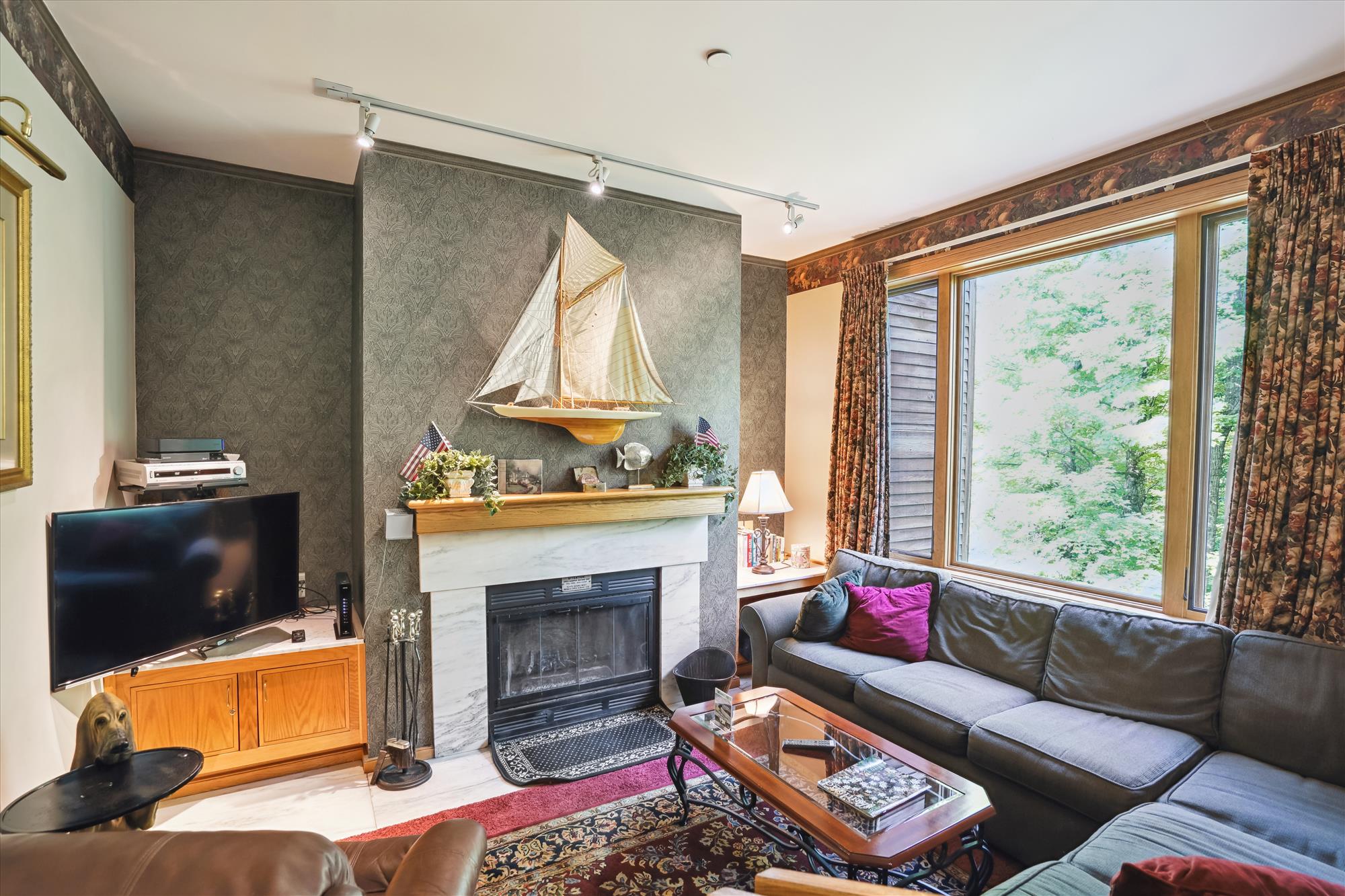 Tastefully decorated living room. Enjoy the warm glow from the wood burning fireplace.