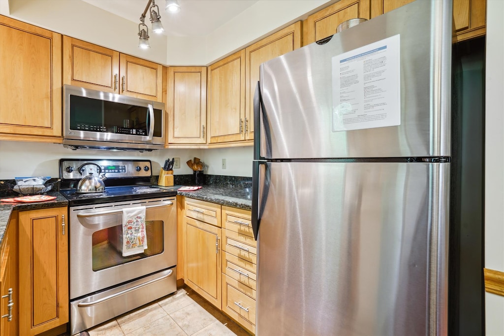 Modern kitchen featuring maple cabinetry, granite counters, and full-size appliances. Enjoy everything you need for cooking at home during your stay.