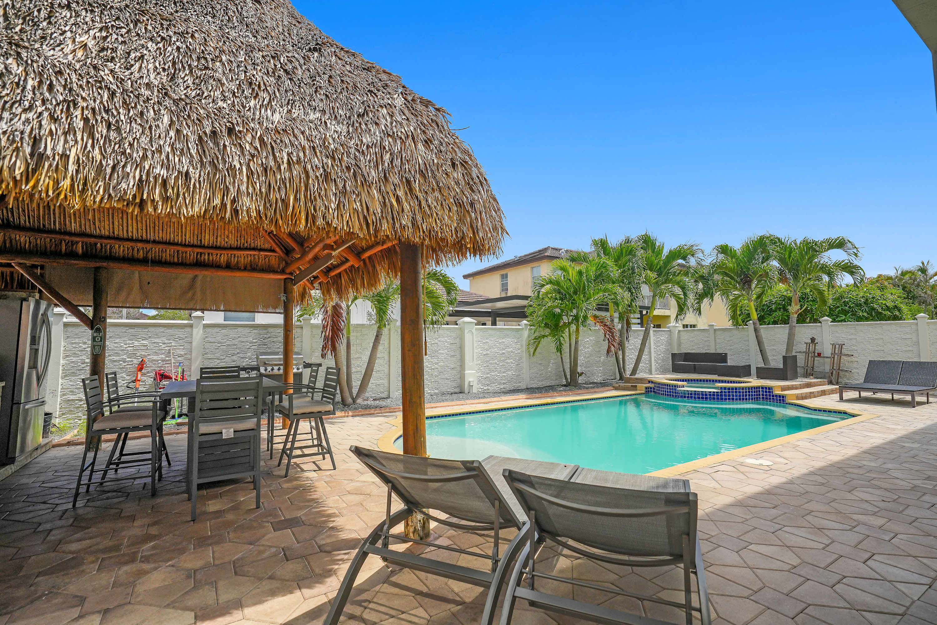 This backyard is a tropical pool oasis for you to enjoy! Relax on the loungers, take a dip in the pool, and enjoy al fresco dining under the patio!