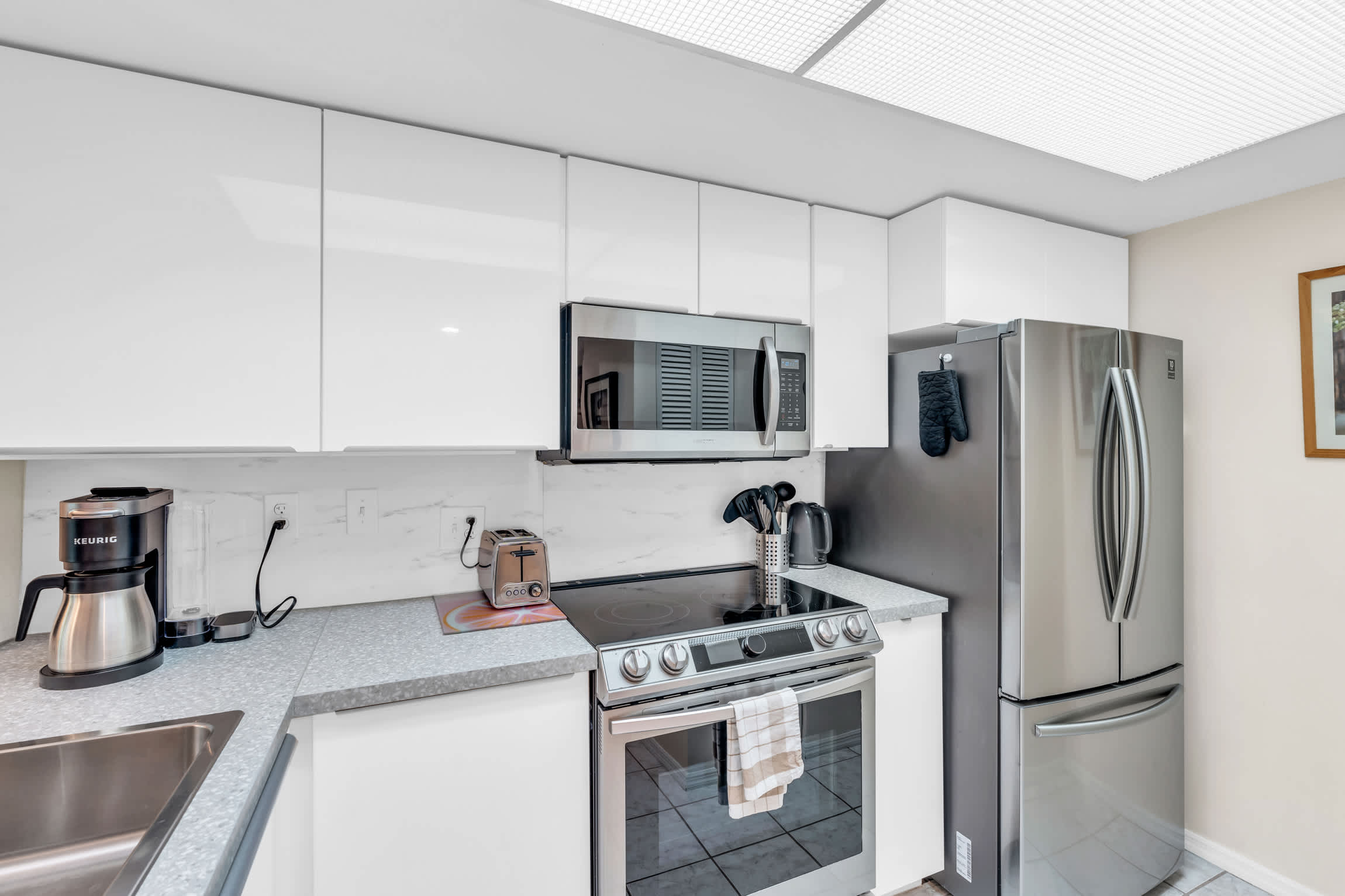 The kitchen contains a full package of stainless steel appliances