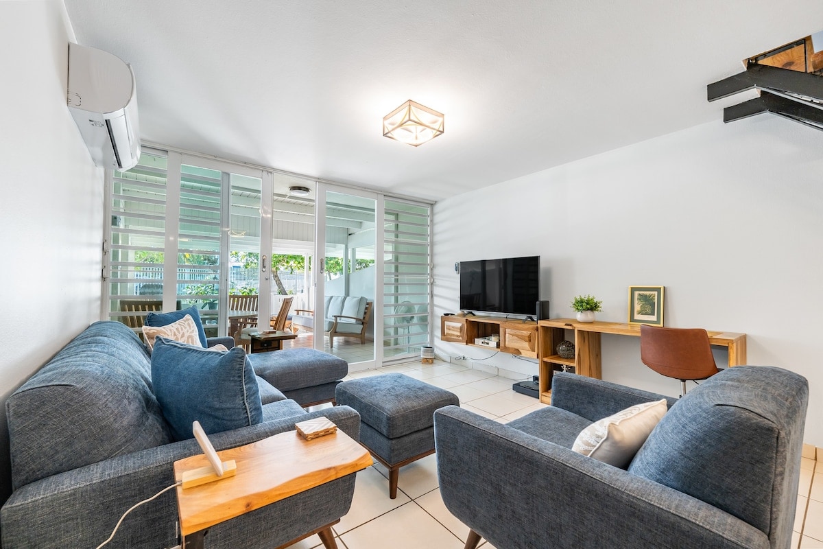 Open-space design with kitchen and dining area to one side, while on the other, leading out to a furnished patio.