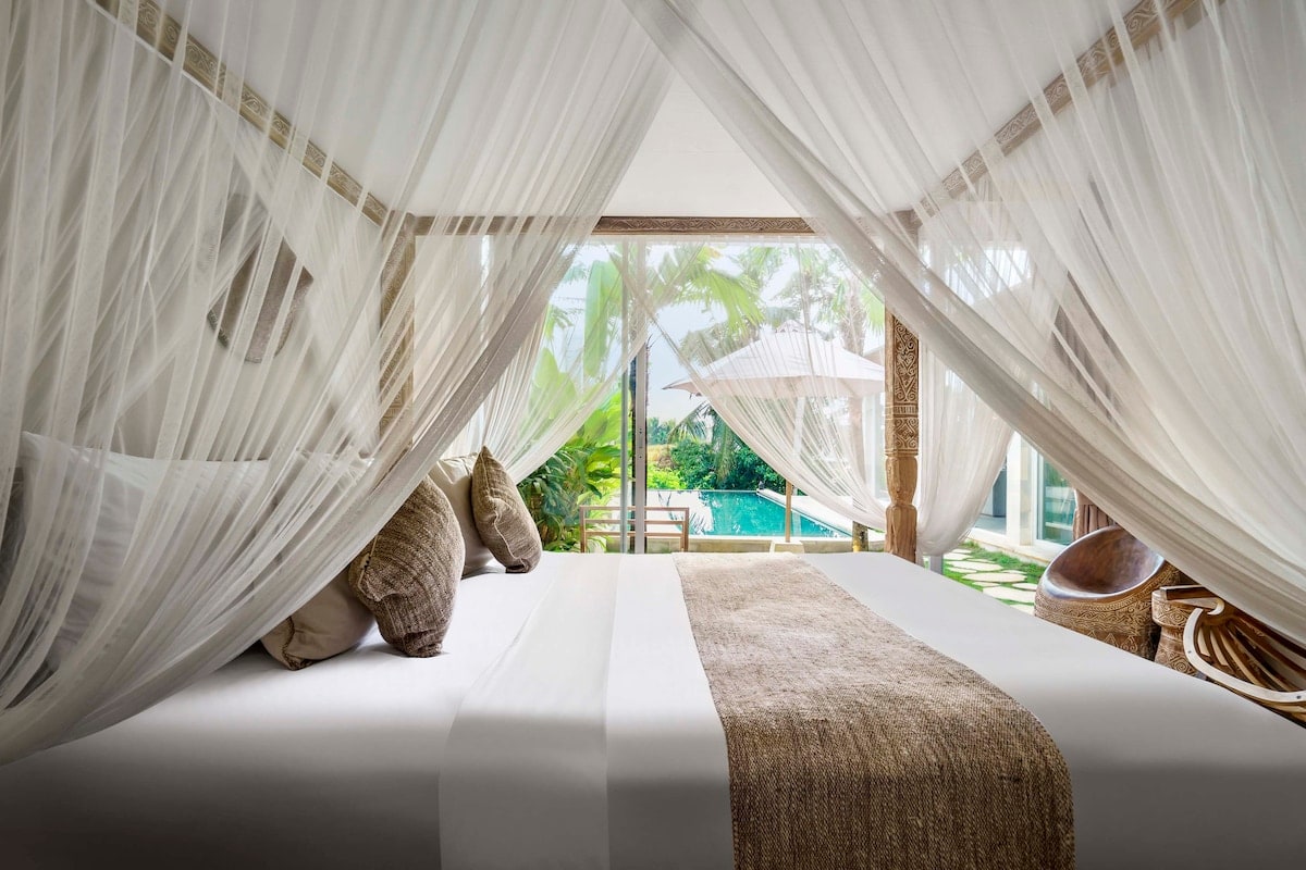 Beautiful bedroom with an outside view of the turquoise pool 