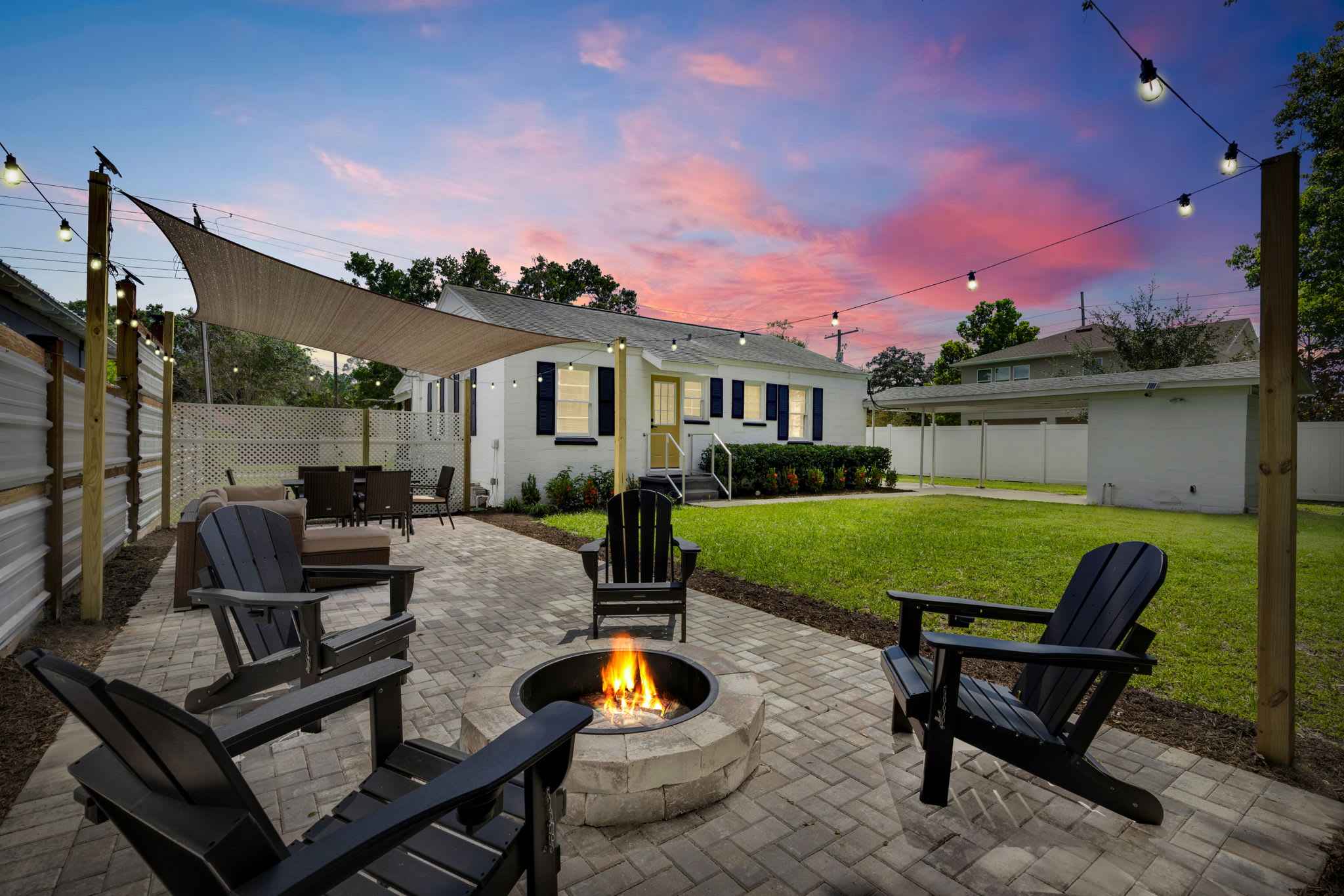 Unwind in our massive backyard space, where a cozy firepit and inviting outdoor patio come to life at twilight