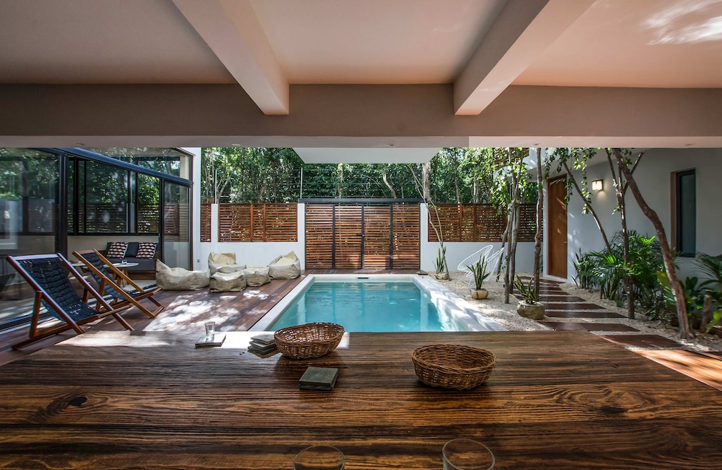 Serenene pool views from a beautifully designed outdoor dining area, perfect for relaxing and entertaining.