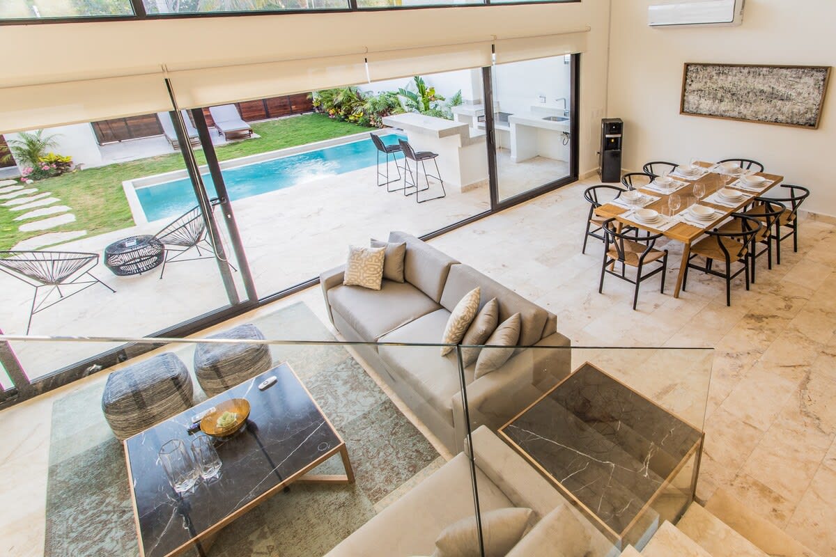 Spacious living-dining room with large windows connecting to the outside.