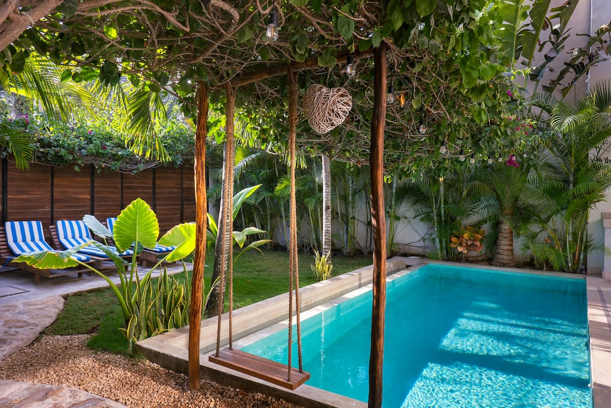 Beautiful hammock with decorative roof next to the pool.