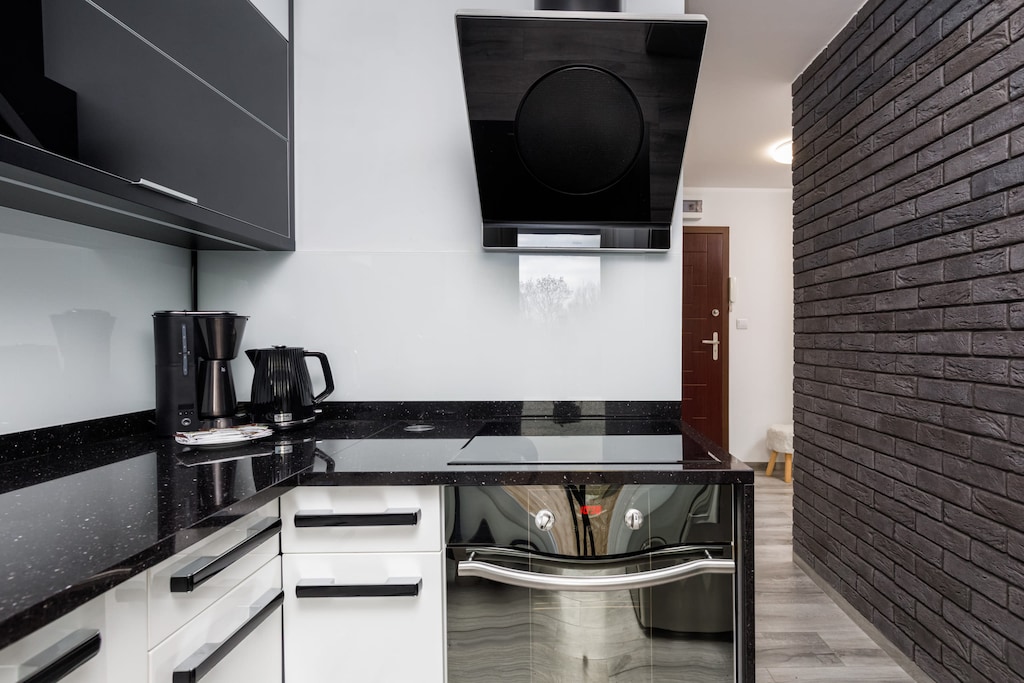 A sleek black and white kitchen with modern appliances and a contemporary design.
