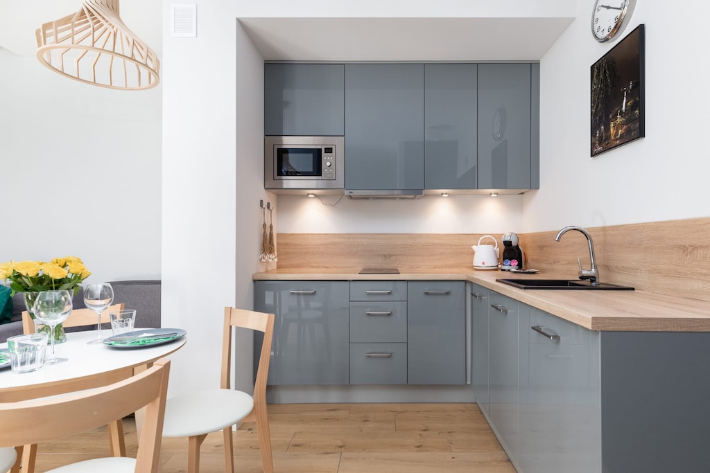 A modern kitchen with gray cabinetry, wood countertops, and built-in appliances, designed for efficiency and style.