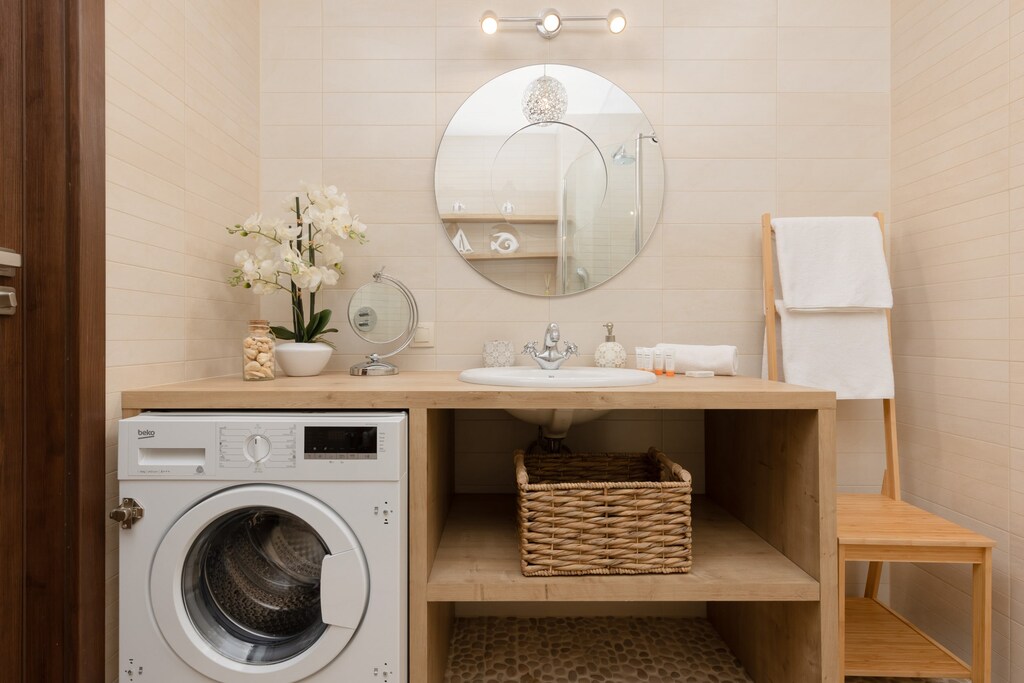 Bright bathroom with washing machine and shower cabin. 