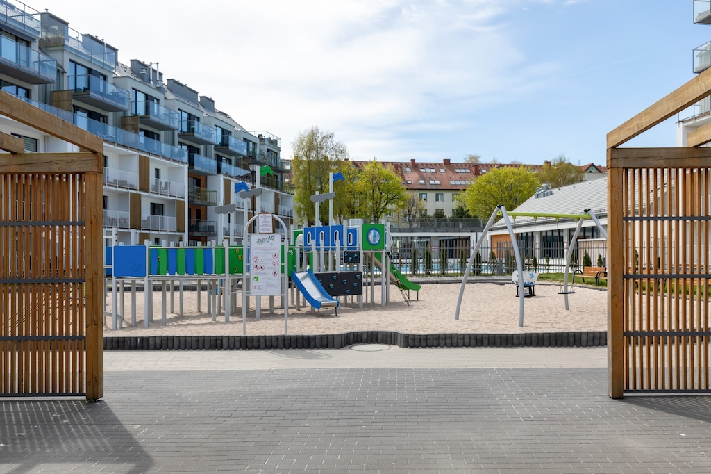 An outdoor seating area surrounded by modern buildings and landscaped pathways.

