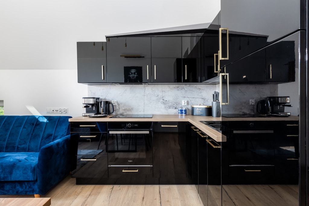 Modern kitchen with sleek black cabinets, built-in appliances, and a contemporary design.

