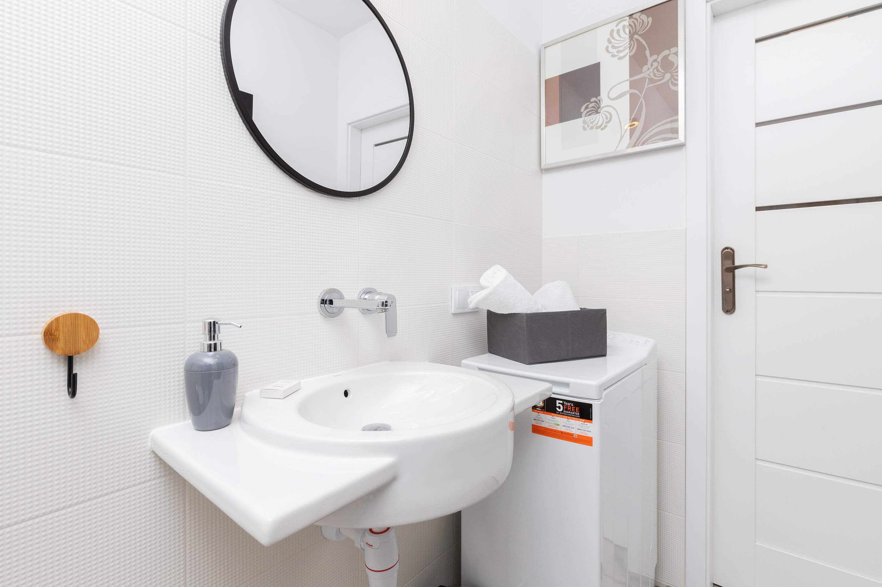 Bathroom with a shower, sink with mirror, toilet, hair dryer and washing machine.