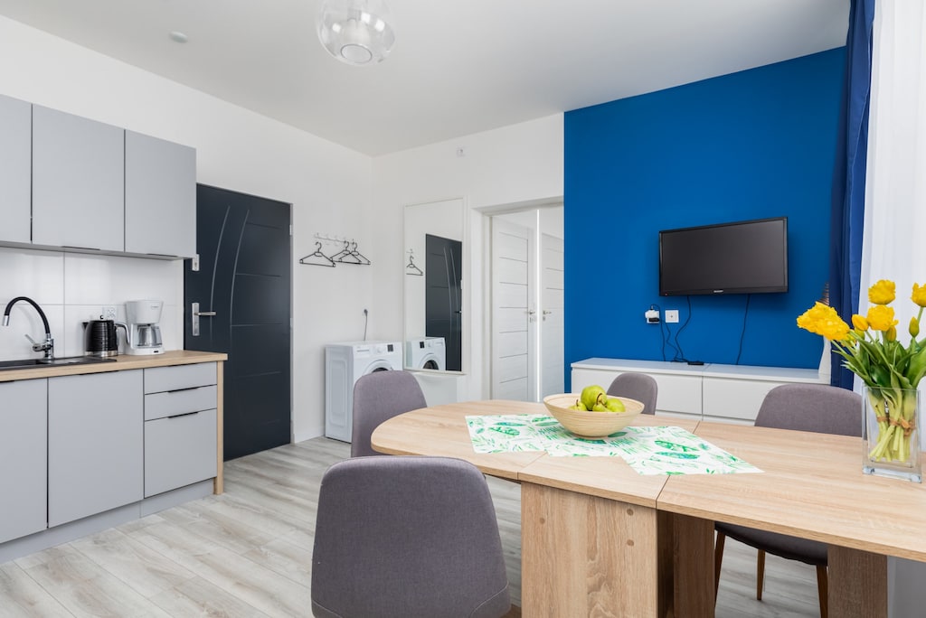 Another angle of the living and dining space, highlighting the open-plan layout and well-equipped kitchenette.


