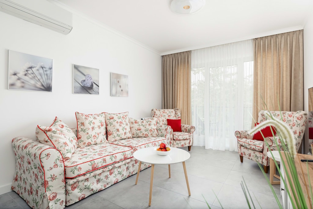 Bright and cozy living room with a sofa bed, TV and access to balcony.
