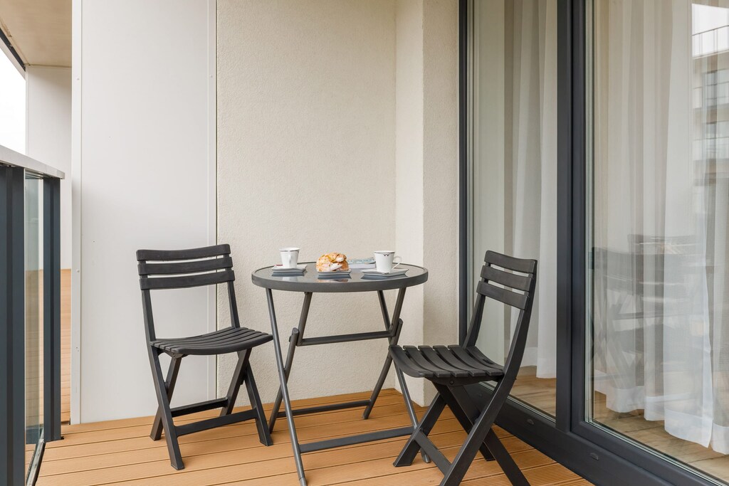 Private balcony with a table and chairs, offering a peaceful spot to enjoy the fresh air and views.
