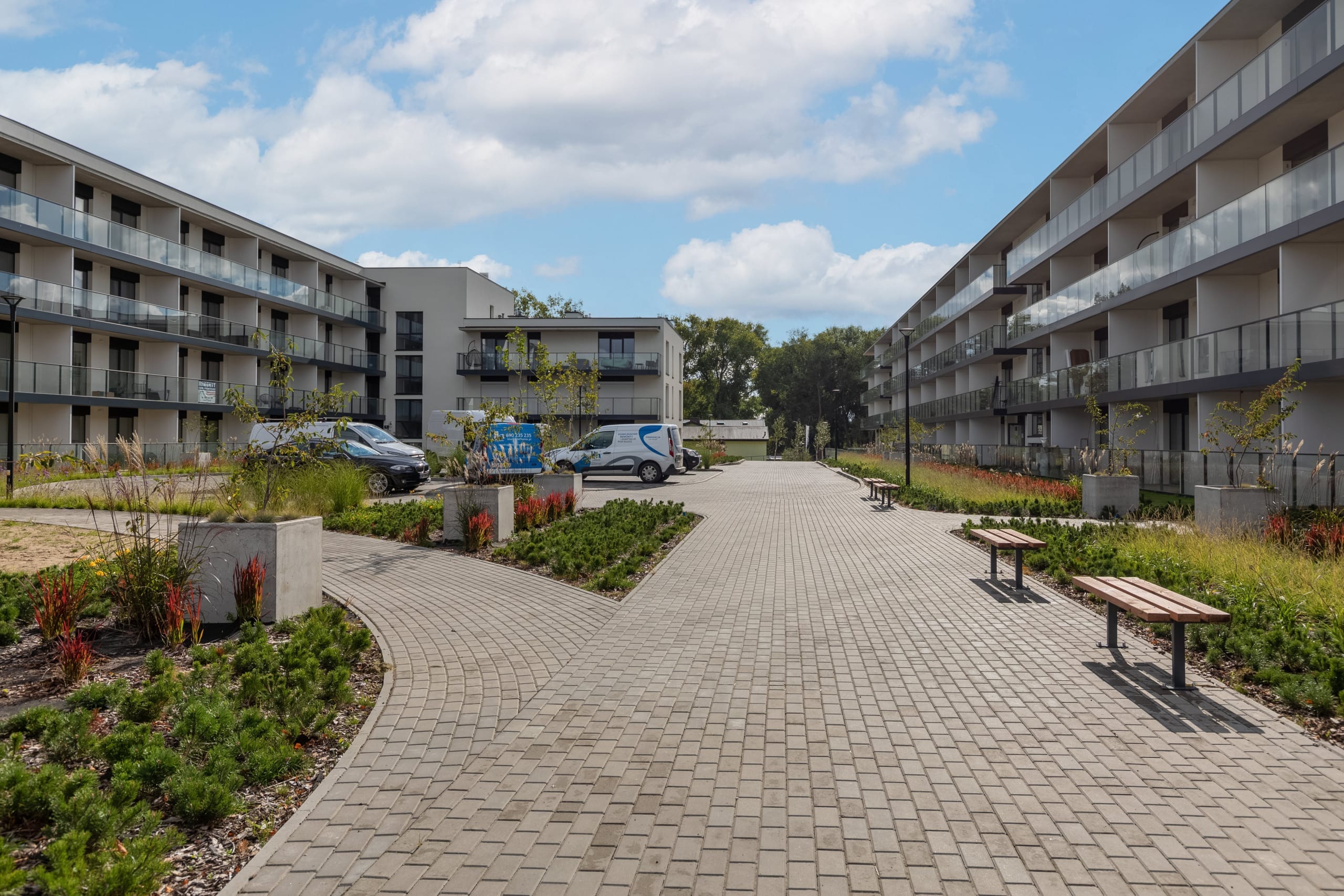 The exterior of a modern residential building with large windows and balconies. The design emphasizes luxury living.