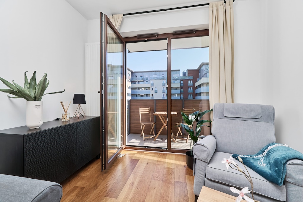 A close-up of a comfortable gray armchair adorned with a teal cushion, positioned next to a small gold side table.