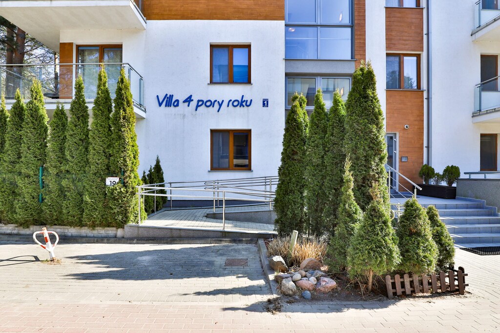 Modern apartment building exterior surrounded by greenery.
