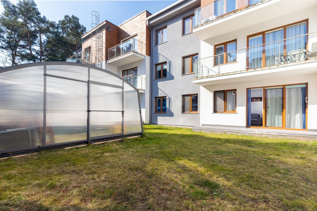 Modern apartment building exterior surrounded by greenery.
