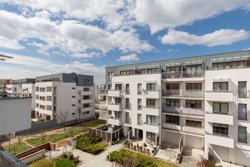 Exterior view of a residential building with modern architecture and open balconies.

