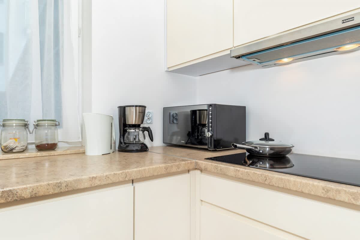 Practically equipped kitchenette with such appliances as an induction hob, a microwave, and a coffee machine.