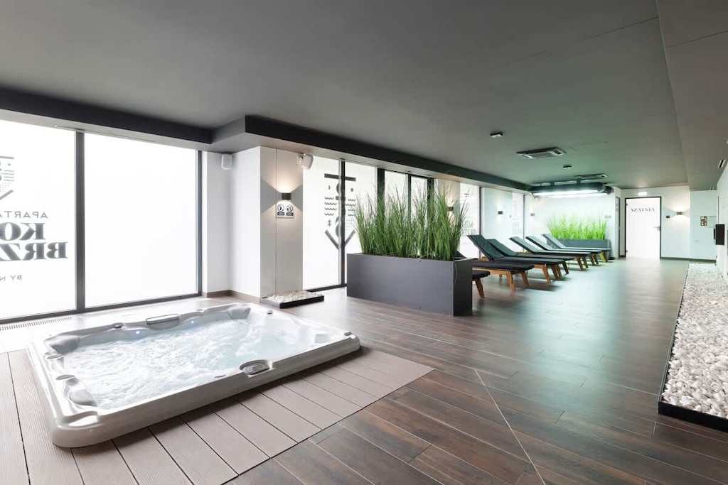 A spacious indoor area with glass walls, plants, and equipment, possibly part of a fitness or wellness center.