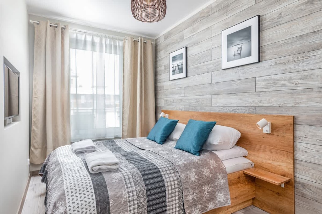 A cozy bedroom with a double bed, wooden side tables, and patterned bedding.