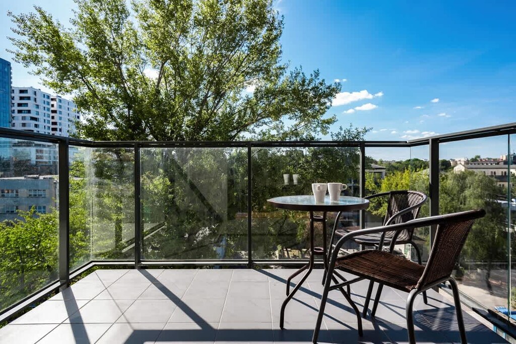 Spacious terrace with a table and chairs, perfect for morning coffee with a city view.