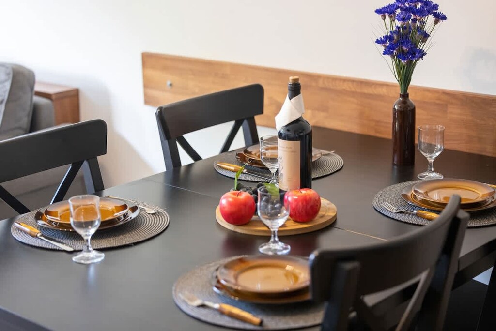 A close-up of a dining table beautifully set with wine, fruits, and pastries, creating an inviting atmosphere.