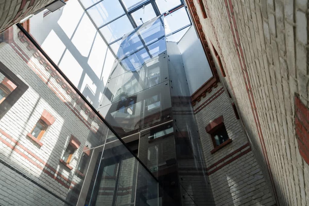 A unique architectural feature showing a glass ceiling atrium with industrial-style brick walls and windows.