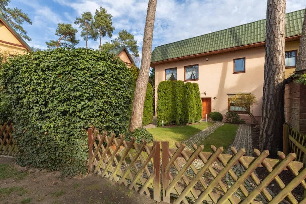 A view of the house's backyard, showing a neatly kept garden with a wooden fence.