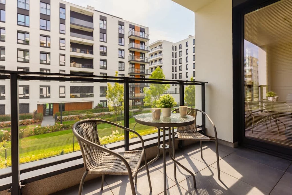 A private balcony with a seating area and views of the surrounding residential area.
