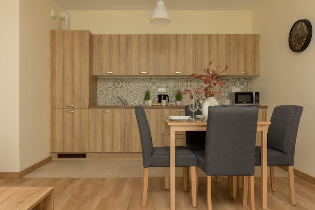 A stylish dining area with a wooden table, gray chairs, and a minimalist design.
