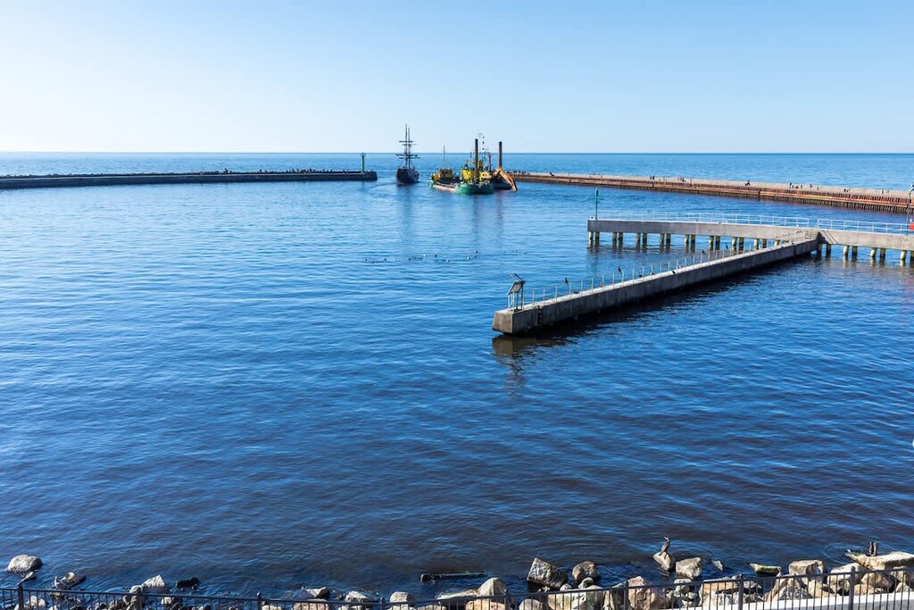 A breathtaking view of the sea with a pier extending into the water, creating a serene coastal scene.

