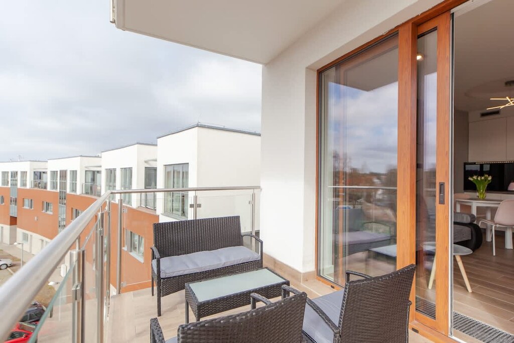 Spacious balcony with outdoor furniture. 