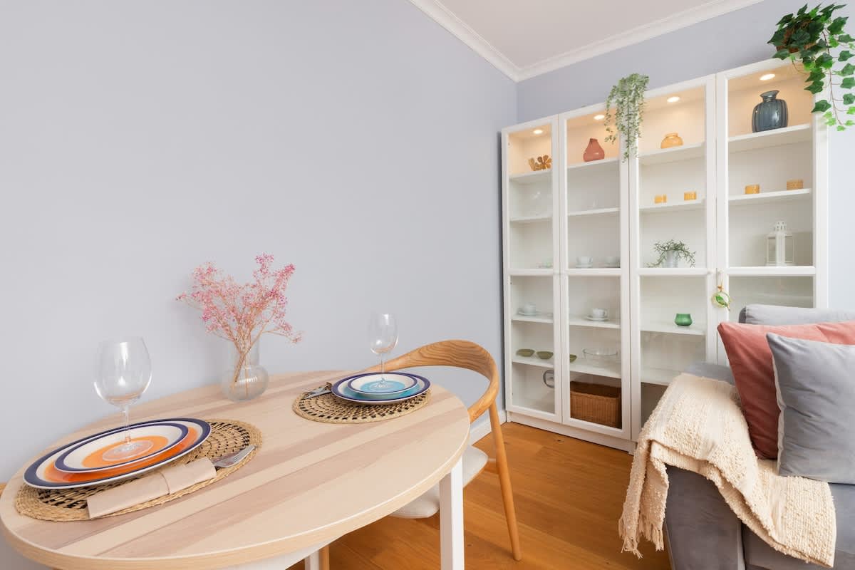 Bright living room with a cozy sofa, decorative pillows, and a coffee table, featuring soft, pastel decor.