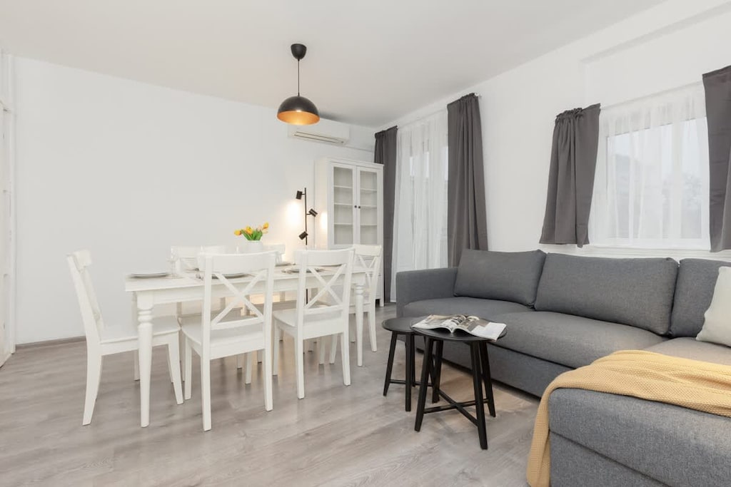 A cozy living area with a modern sofa, a TV, and a small coffee table, decorated in a minimalist style.
