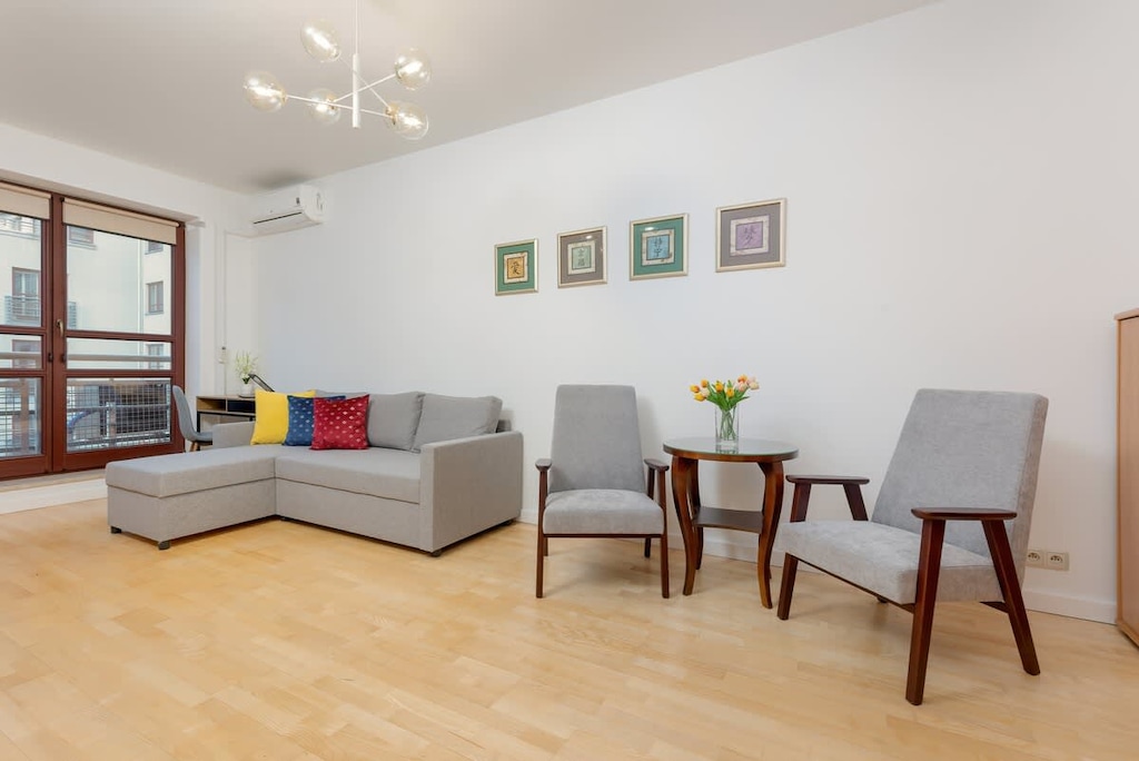 A spacious living room with a gray corner sofa, a wooden table, and modern decor.