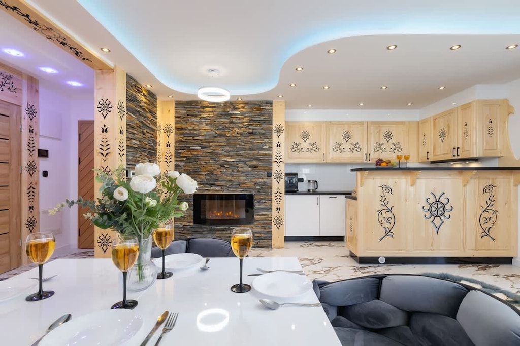 Living room with a sofa bed, TV and kitchenette.