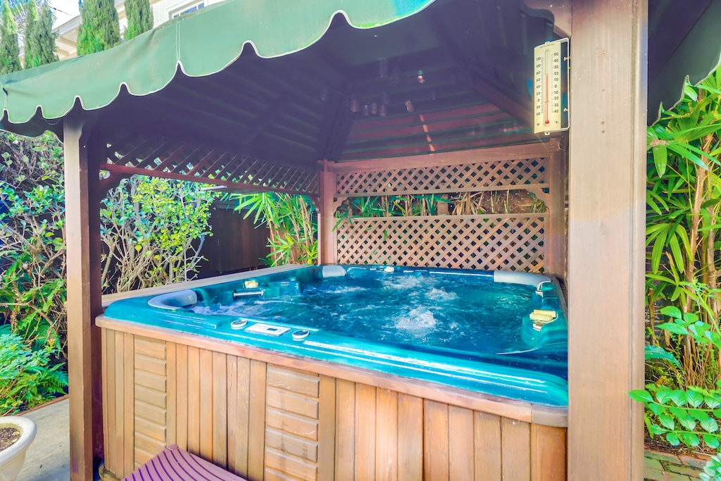 Private hot tub beneath a shaded pergola.