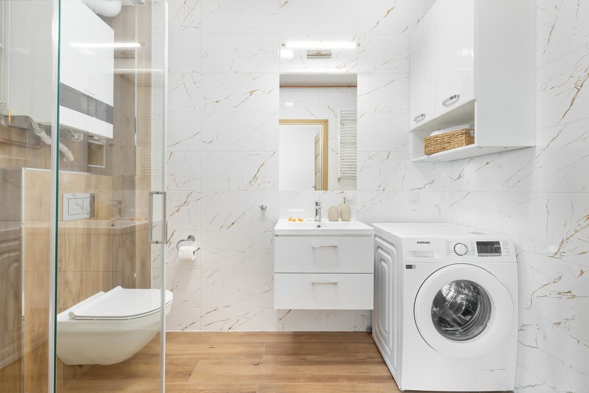 Bathroom with washing machine and towels. 