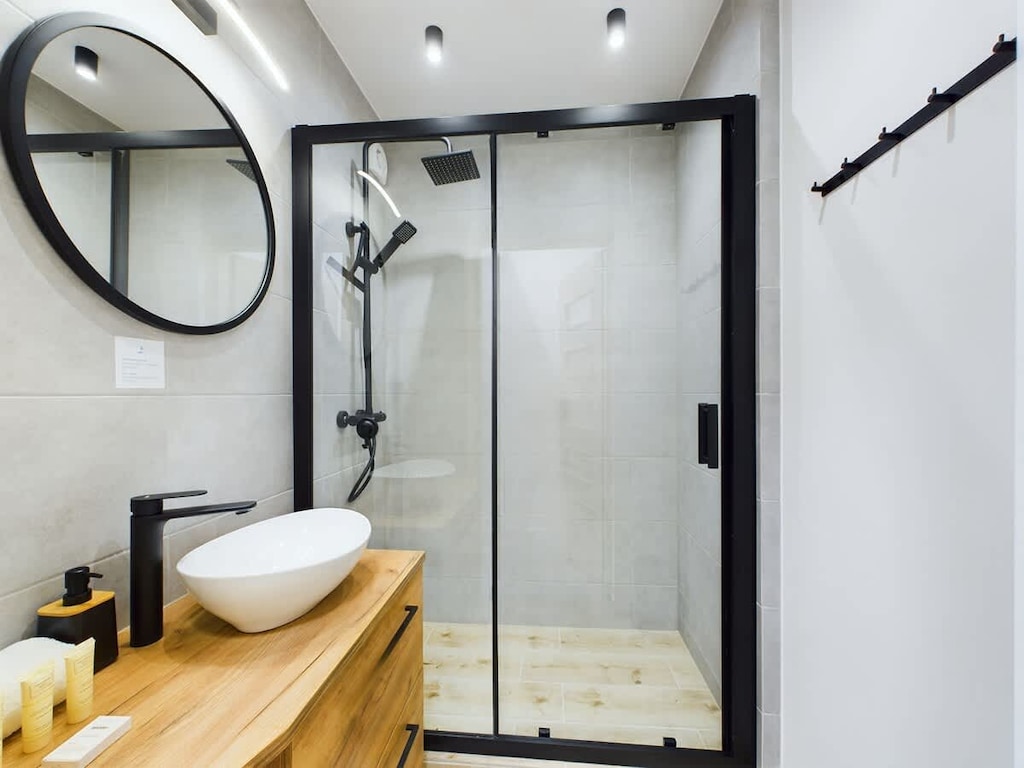 The bathroom's contemporary design includes fresh towels and a hairdryer. 