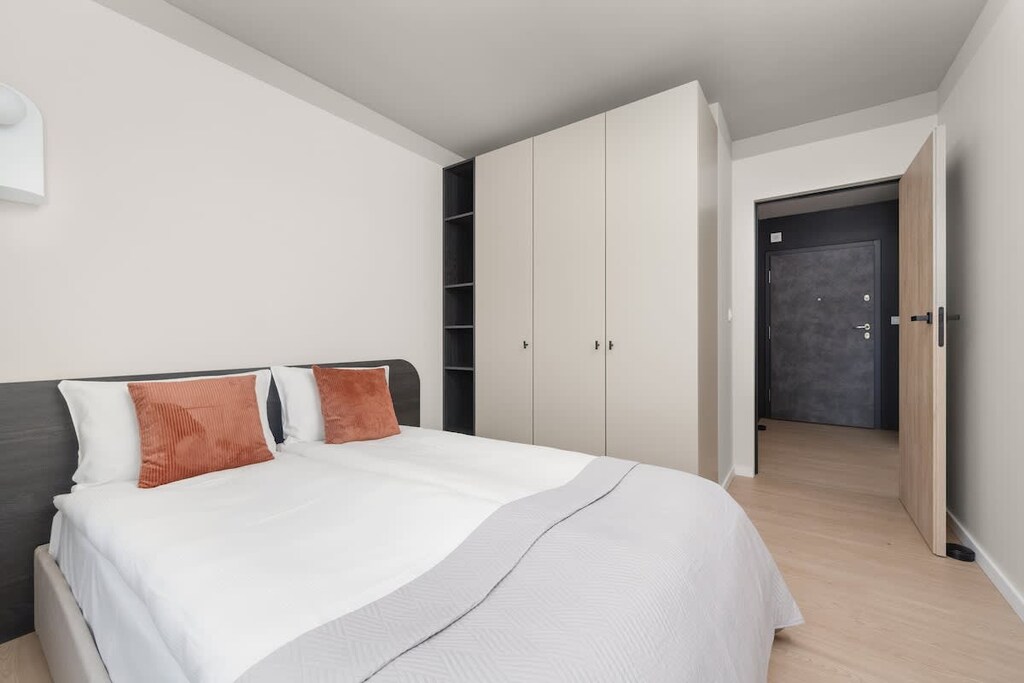 Bedroom with orange accent pillows
A minimal yet stylish sleeping area with bold color touches.
