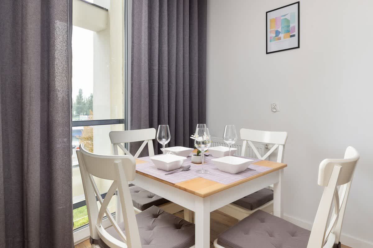 Dining area with a wooden table set for four people.