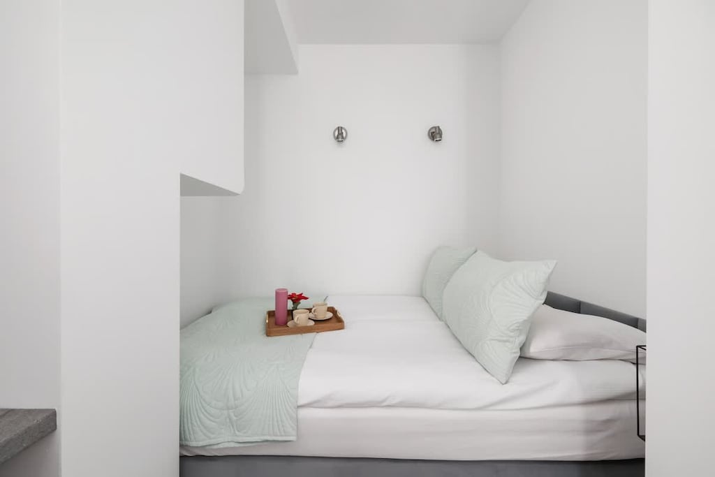 Cozy bedroom with a simple bed setup, soft lighting, and minimal decor