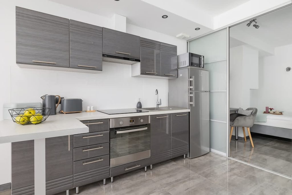 Sleek kitchen with grey cabinets, under-cabinet lighting, and modern appliances.