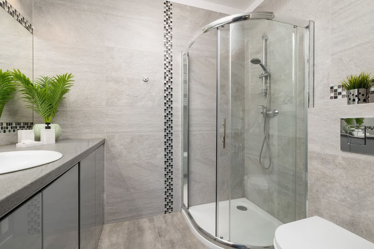 Bathroom with a large mirror, vanity sink, and a warm-toned wooden door.