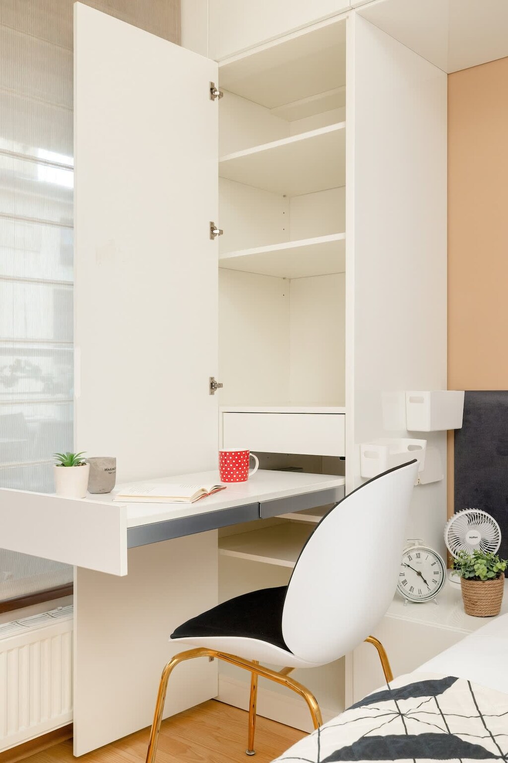 A practical area with a built-in desk, office chairs, and open shelving above the workstation.