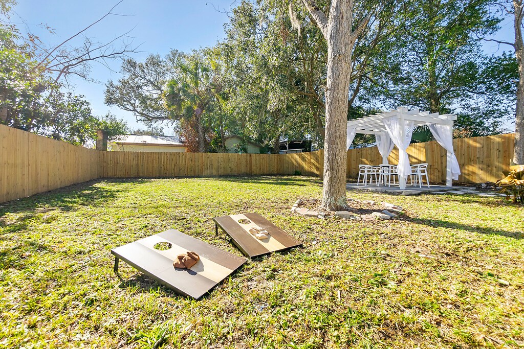 A spacious backyard with cornhole and outdoor dining area to enjoy the Florida sunshine