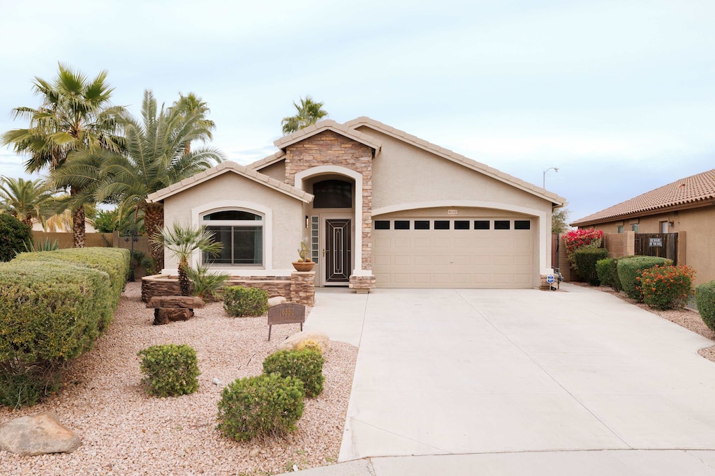 Charming single-story home with desert landscaping and a spacious driveway.